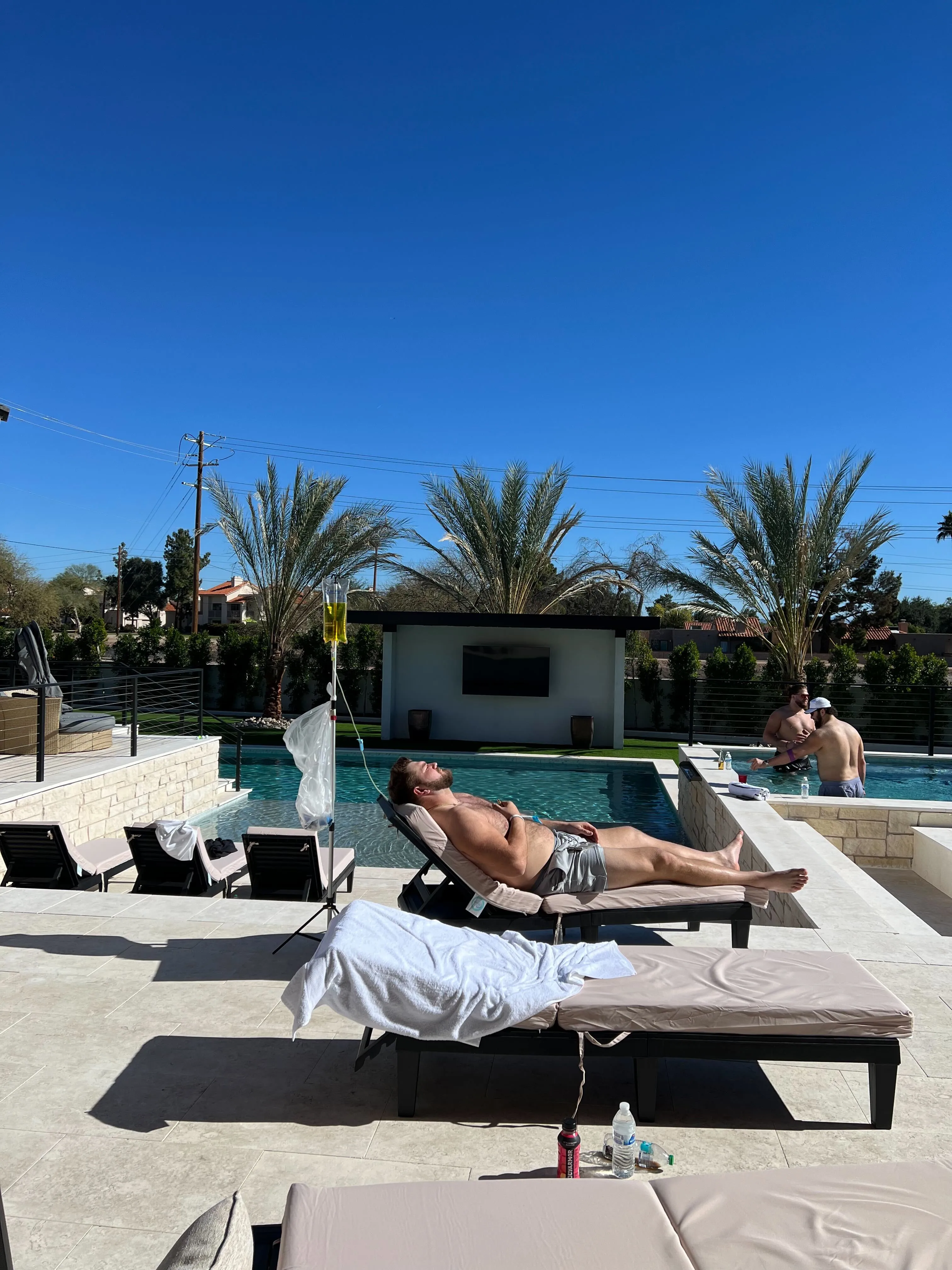 Client recovering with IV hydration by Scottsdale pool after outdoor activity